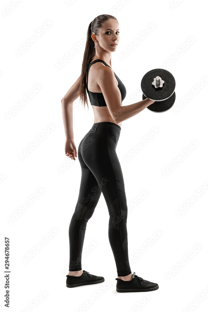 Fototapeta premium Brunette woman in black leggings, top and sneakers is posing isolated on white. Fitness, gym, healthy lifestyle concept. Full length.