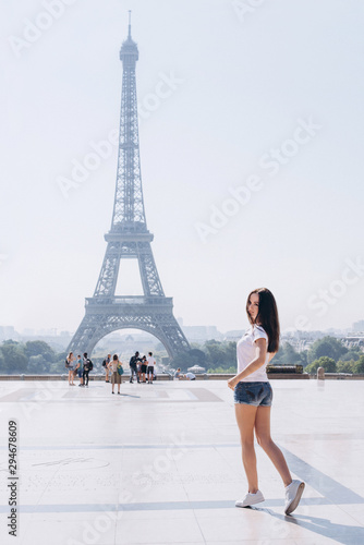 Woman tourist at Eiffel Tower smiling. Beautiful European young girl enjoying vacation in Paris, France. Travel concept. © YM studio