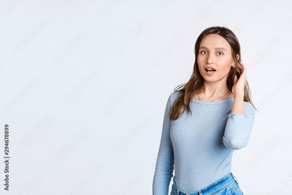 Beautiful girl in surprise rejoices and straightens her hair, widen eyes astonished, open mouth, standing on white background impressed. Good news. Add your text Beautiful girl in surprise rejoices and straightens her hair, widen eyes astonished, open mouth, standing on white background impressed. Good news. Add your text