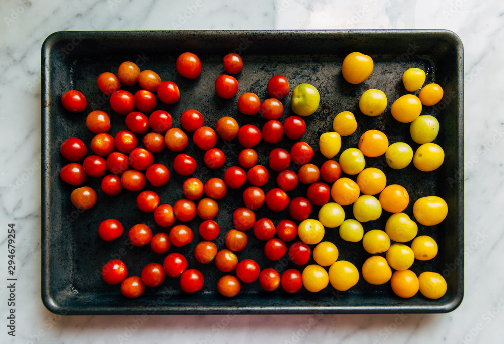 little tomatoes on a baking pan little tomatoes on a baking pan