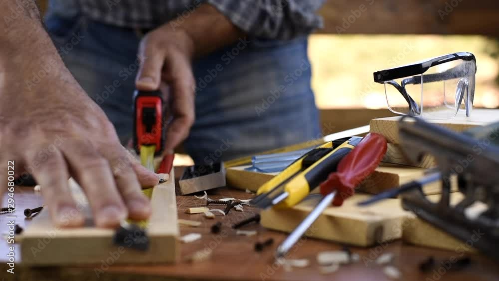 Adult carpenter craftsman takes the measure and with the carpenter's square trace the cutting line on a wooden table. Construction industry, housework do it yourself. Footage. Adult carpenter craftsman takes the measure and with the carpenter's square trace the cutting line on a wooden table. Construction industry, housework do it yourself. Footage.
