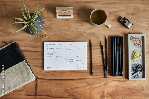 Overhead still life of a weekly calendar on a wooden desk