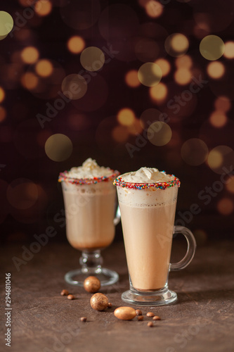 New year or holiday warming drink, latte with colorful sprinkles. On a brown concrete background. Bokeh. 