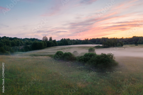 Magnificent sunset and mist spreading across the field, Leningrad region, Russia