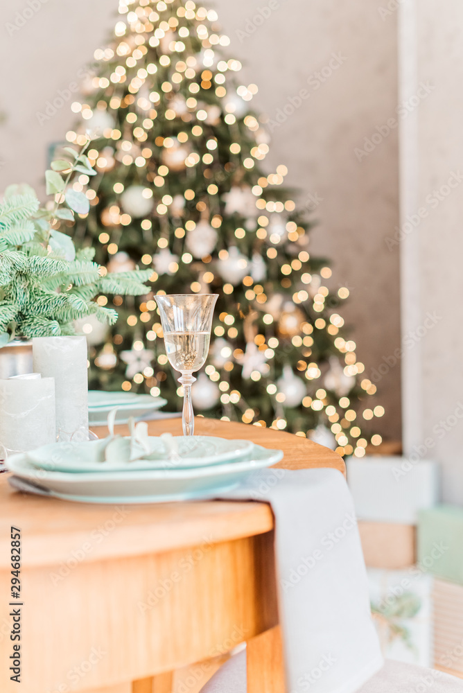 Christmas wooden table, a glass of champagne and christmas tree, table setting