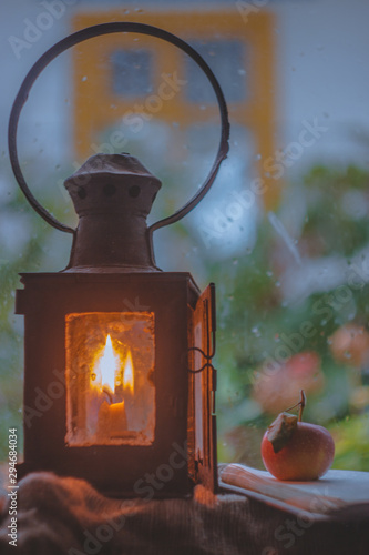 Still life with vintage lamp. Rainy day outside the window