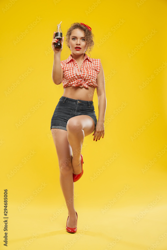 Gorgeous young lady with blonde hair keeping bottle of soda Gorgeous young lady with blonde hair keeping bottle of soda