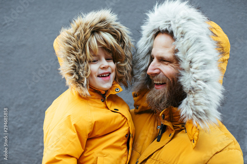 Father and kid wearing yellow hooded coat. photo