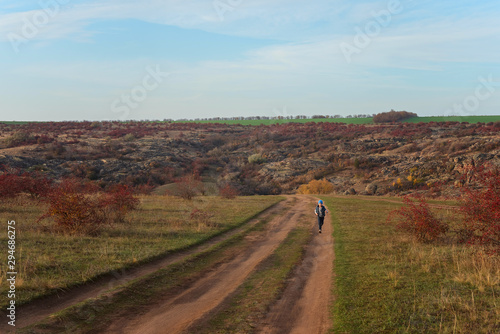 Running boy on road to canyon. Beautiful landscape of the autumn canyon and the road to it