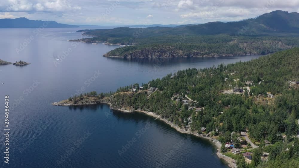 Aerial view over inlet, ocean and island with boat and mountains in beautiful British Columbia. Canada. 4K. Aerial view over inlet, ocean and island with boat and mountains in beautiful British Columbia. Canada. 4K.