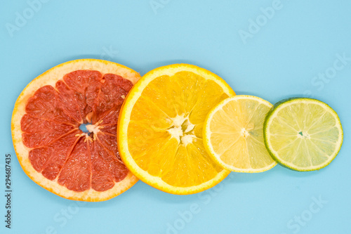 various citrus slices of orange lime lemon and grapefruit arranged on colorful background abstract wallpaper with copy space