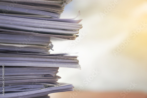 Paper stack on the desk related to business functions.