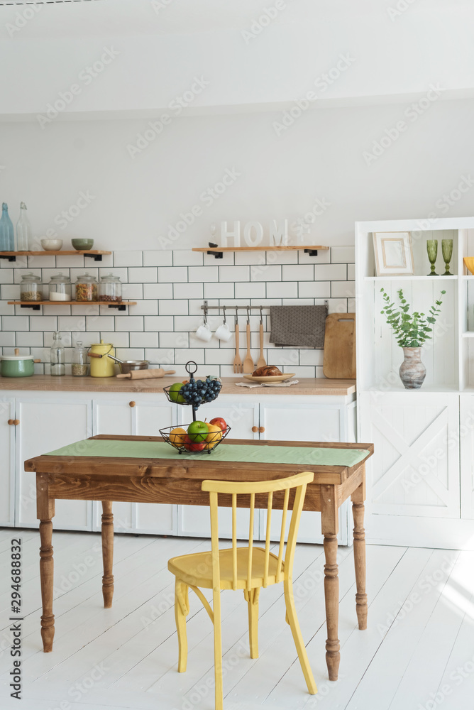 Obraz premium Light white kitchen in modern style with yellow wood chair and wood table