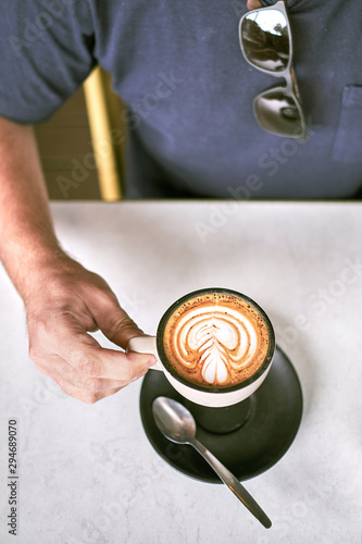 man holding a coffee photo