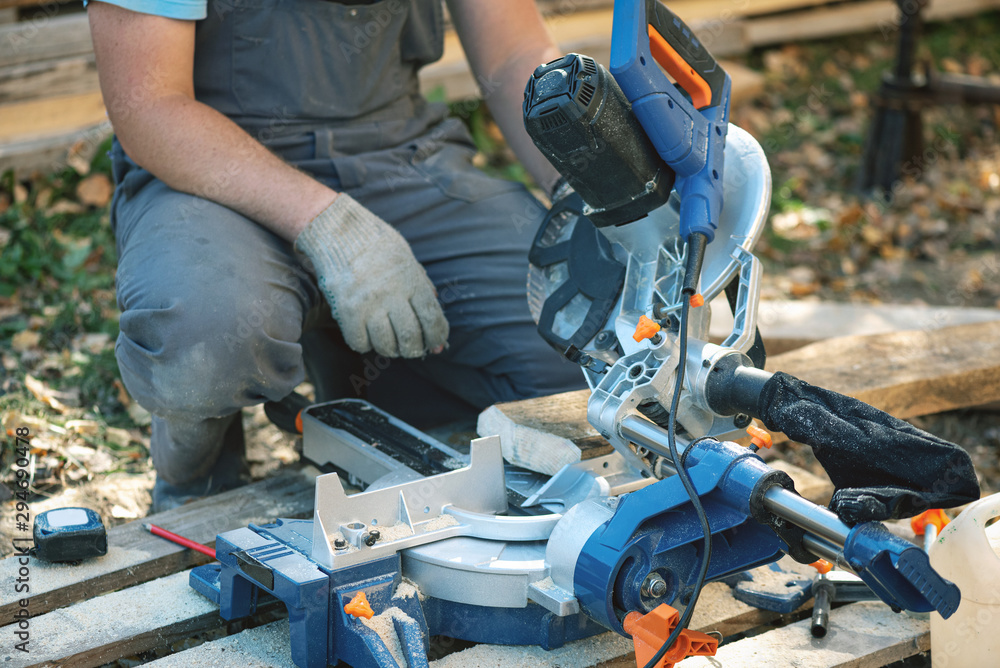 Worker is cutting a wood by a circular saw. Woodwork.