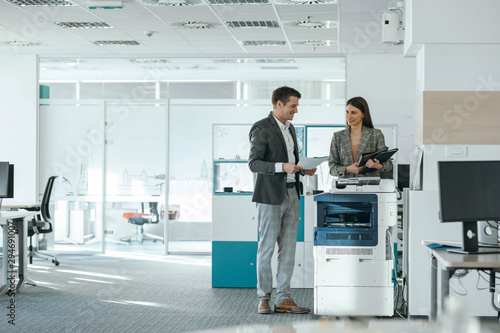 Colleagues Chatting by the Copy Machine