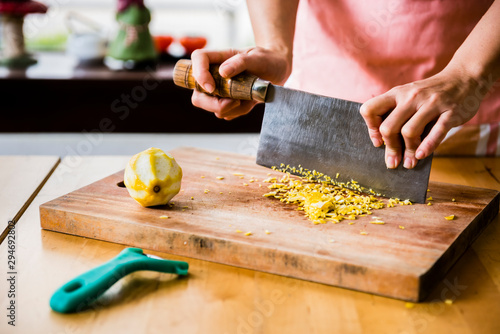 Dessert master mince lemon peel on wooden cutting board