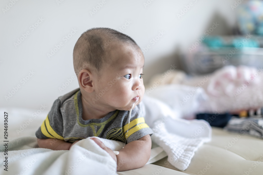 baby Infant 4 months vomiting milk during tummy time foto de Stock