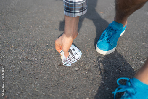 person find paper money lost and dropped on the asphalt ground outdoor