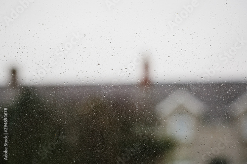 A rainy window with blurry rooftops and chimney pots. The UK. photo