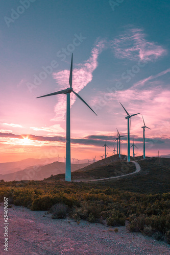 Wind turbines on beautiful sunny summer purple autumn mountain landsape. Curvy road through mountain Eolic park. Green ecological power energy generation. Wind farm eco field