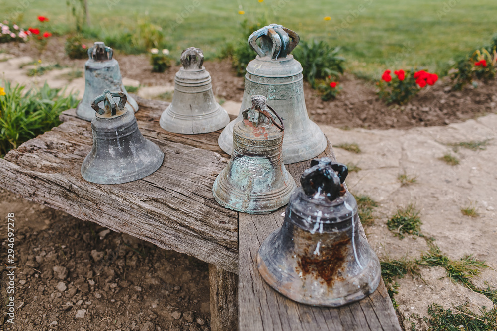 Large, old iron bells on a wooden chair.