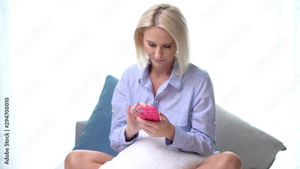 Adult woman relaxing at home and using smartphone Adult woman relaxing at home and using smartphone