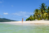 Woman standing on beach in the caribbean sea, white beach and blue sky, cayo levantado