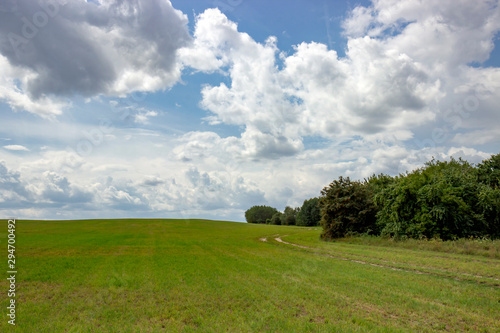 Old constSummer sky over a hilly landscape.ruction of fallen collective farms of Belarus.
