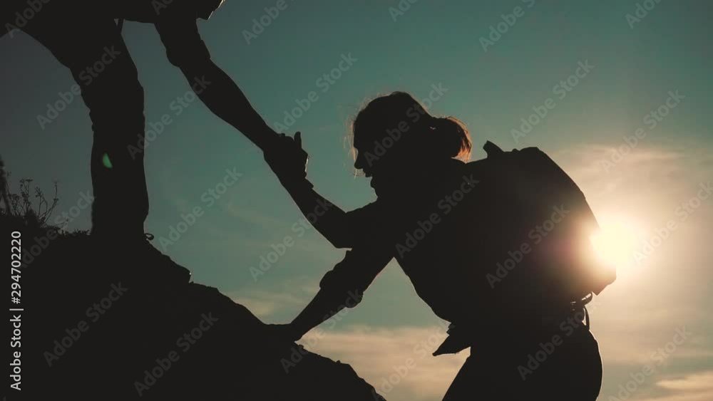 teamwork help business travel silhouette slow motion video concept. Helping hand silhouette between two climbers. teamwork group of tourists lends a helping hand climb the cliffs mountains. couple man