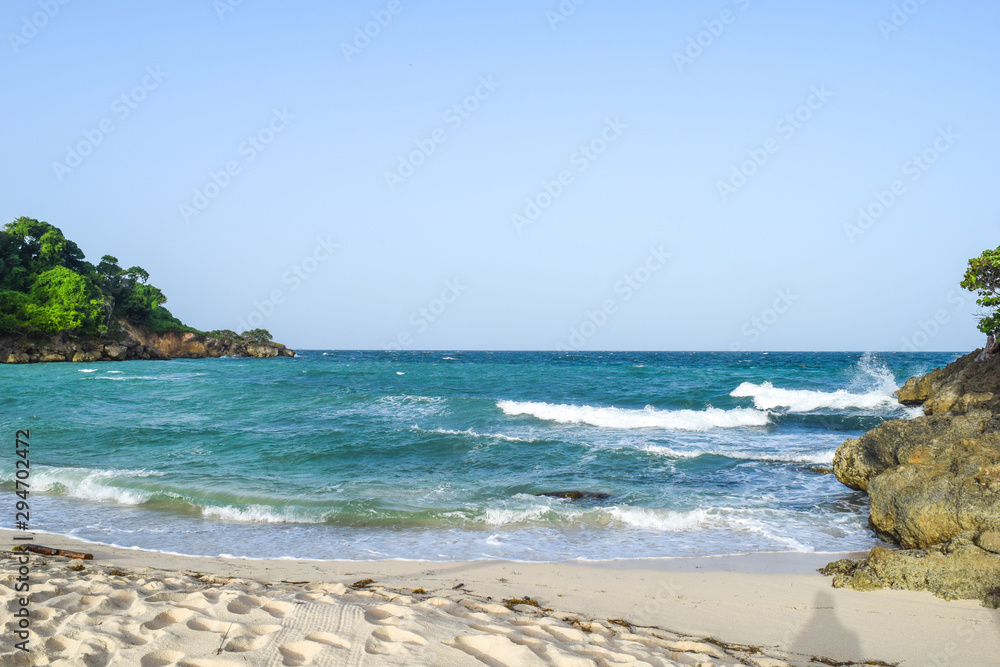 View from beach over the ocean, white sand and turquoise water, caribbean sea