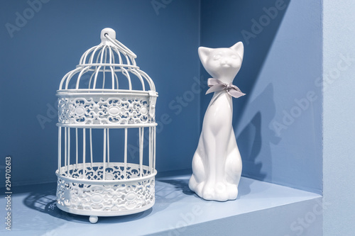 ceramic cat and metal cage in the recess of the blue wall in the apartment photo