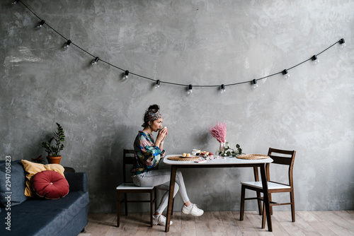 Woman drinking hot beverage in stylish room photo