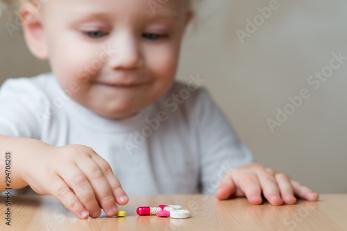 Bilde på lerret baby girl and pills left by adults, close up