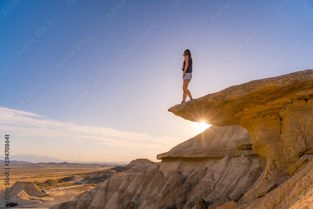 Lifestyle of a young blonde in the Bardenas Reales on top of a stone, Navarra. Spain