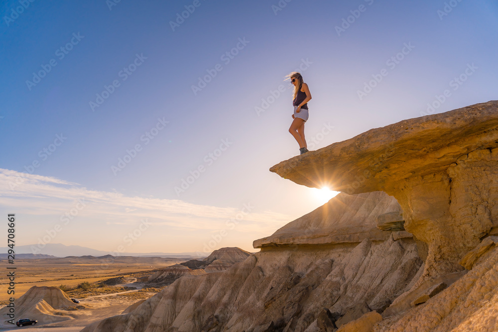 A young woman enjoying the Bardenas Reales on top of a Navarra stone. Spain