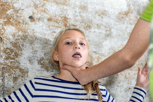 The man wants to strangle the girl, putting his hand to his throat. Production photo. photo