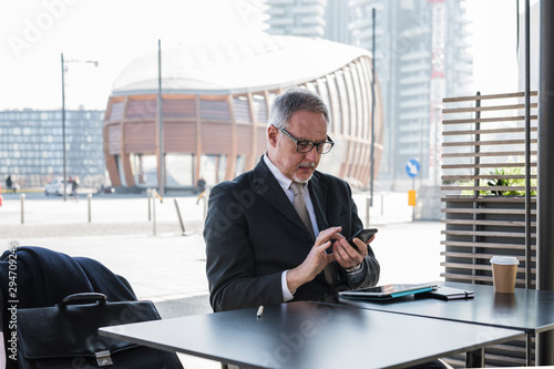 Senior businessman working sititng in a cafe photo