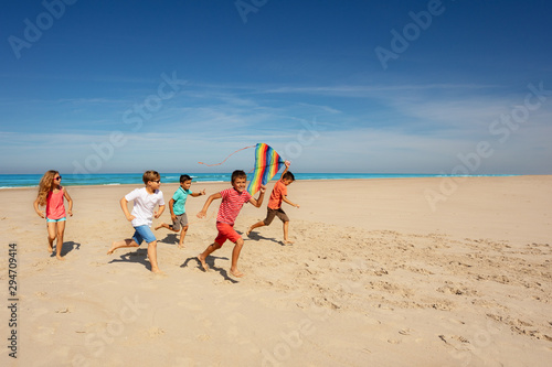 many friends kids run with color kite on the beach