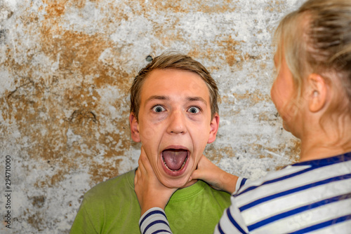 Bilde på lerret The girl strangles the boy, and he raised his hands up and can not breathe