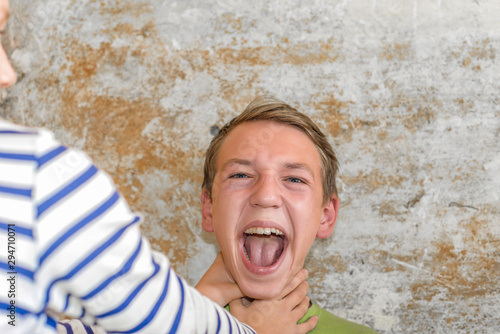 Foto The girl strangles the boy, and he raised his hands up and can not breathe