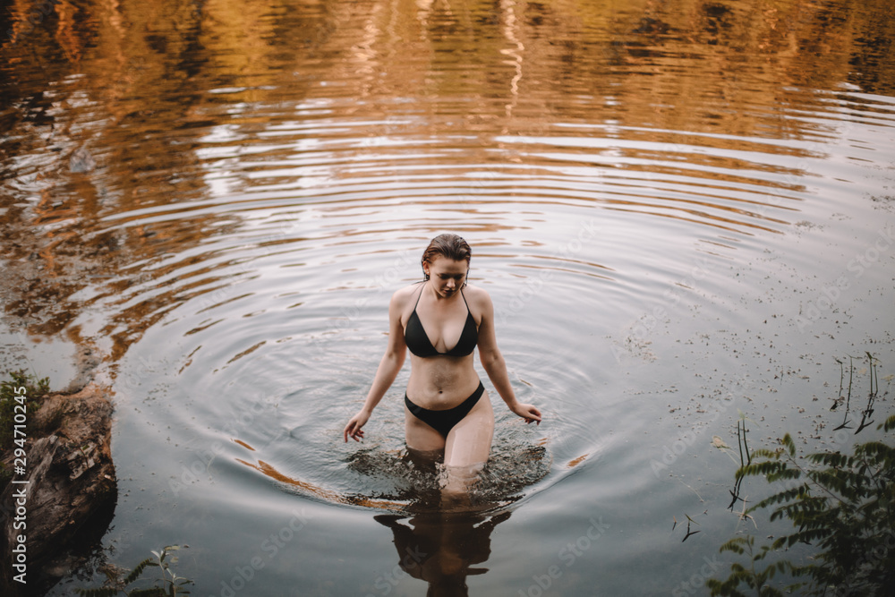 © Cavan Images - Young woman in bikini walking in lake