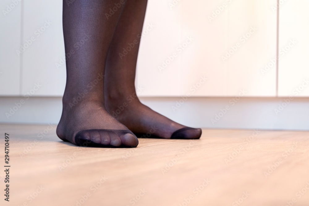 A portrait of the feet of a girl in black pantyhose with the nylon at the  toes being reinforced. Photos | Adobe Stock