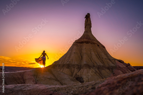 Lifestyle session of a girl in a dress that moves the wind at sunset in the Bardenas. Navarre