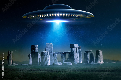 Flying saucer over ancient Stonehenge with light ray in a misty night - 3D rendering and photomanipulation 