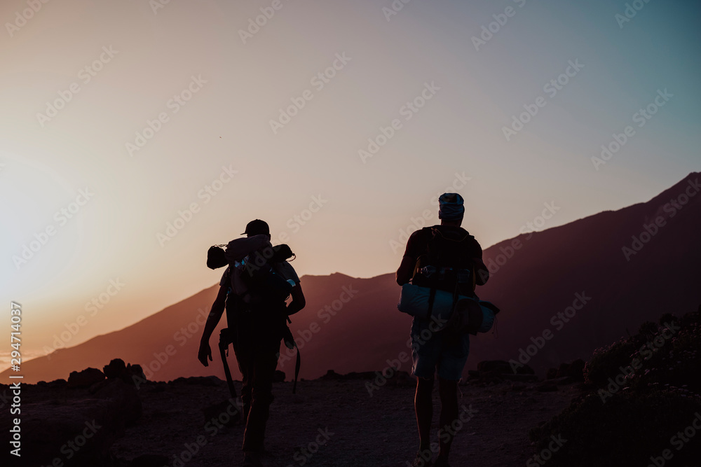 Hikers walking at sunset in Guajara Mountain in el Teide Hikers walking at sunset in Guajara Mountain in el Teide