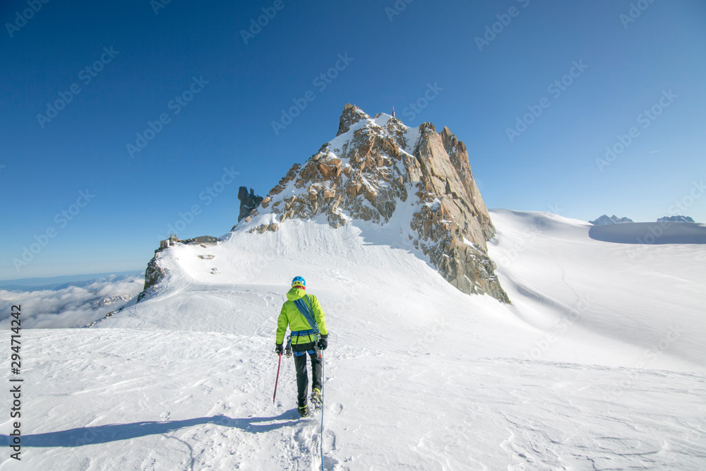 Alpinist crosses a gentle glacier en route to the aiguille du midi Alpinist crosses a gentle glacier en route to the aiguille du midi