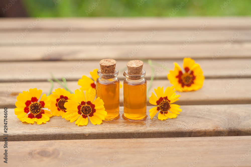 coreopsis essential oil in beautiful bottle on table coreopsis essential oil in beautiful bottle on table