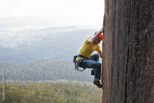 Side view of a male rock climber on diorite pillar, Mount Wellington, Tasmania photo