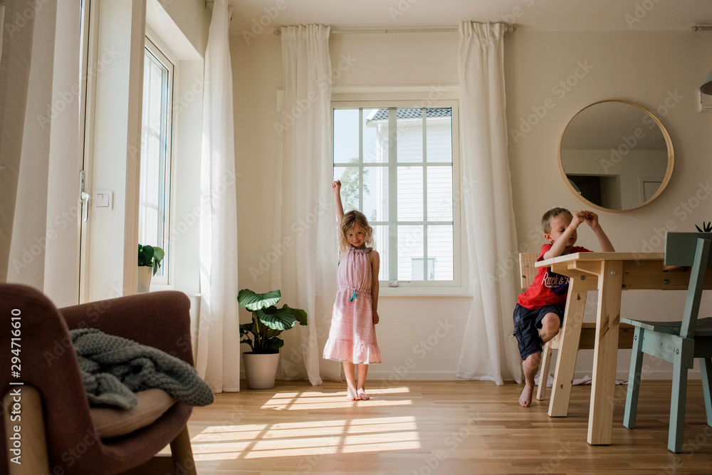 Young girl playing and dancing at home with her brother Young girl playing and dancing at home with her brother